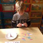 Chłopiec robi zegar z papieru