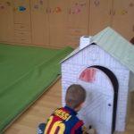 Chłopiec się bawi karotonowym domkiem