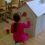 Dziewczynka się bawi karotonowym domkiem